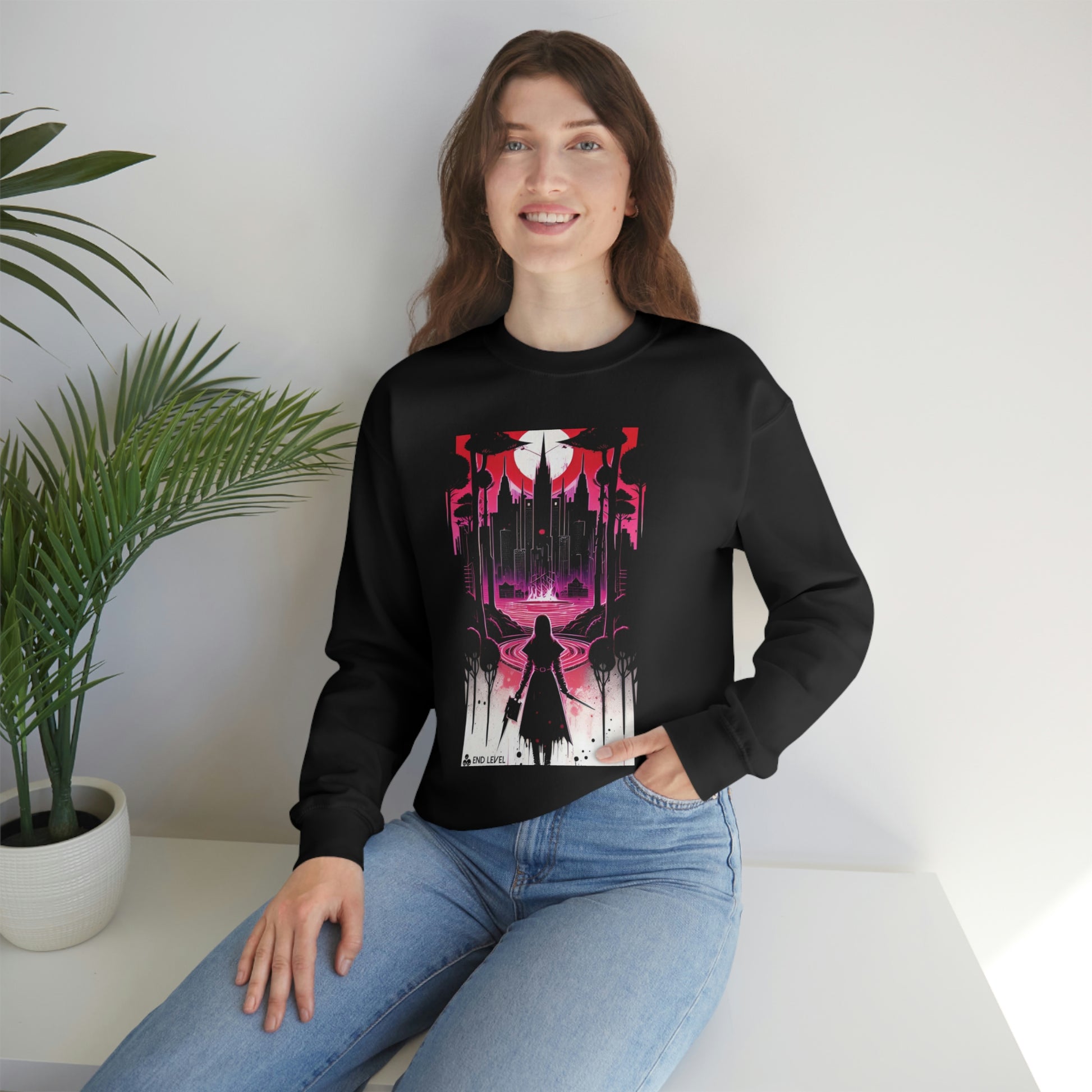Woman with hand in jean pocket wearing black Night Of Malice sweatshirt beside plant.