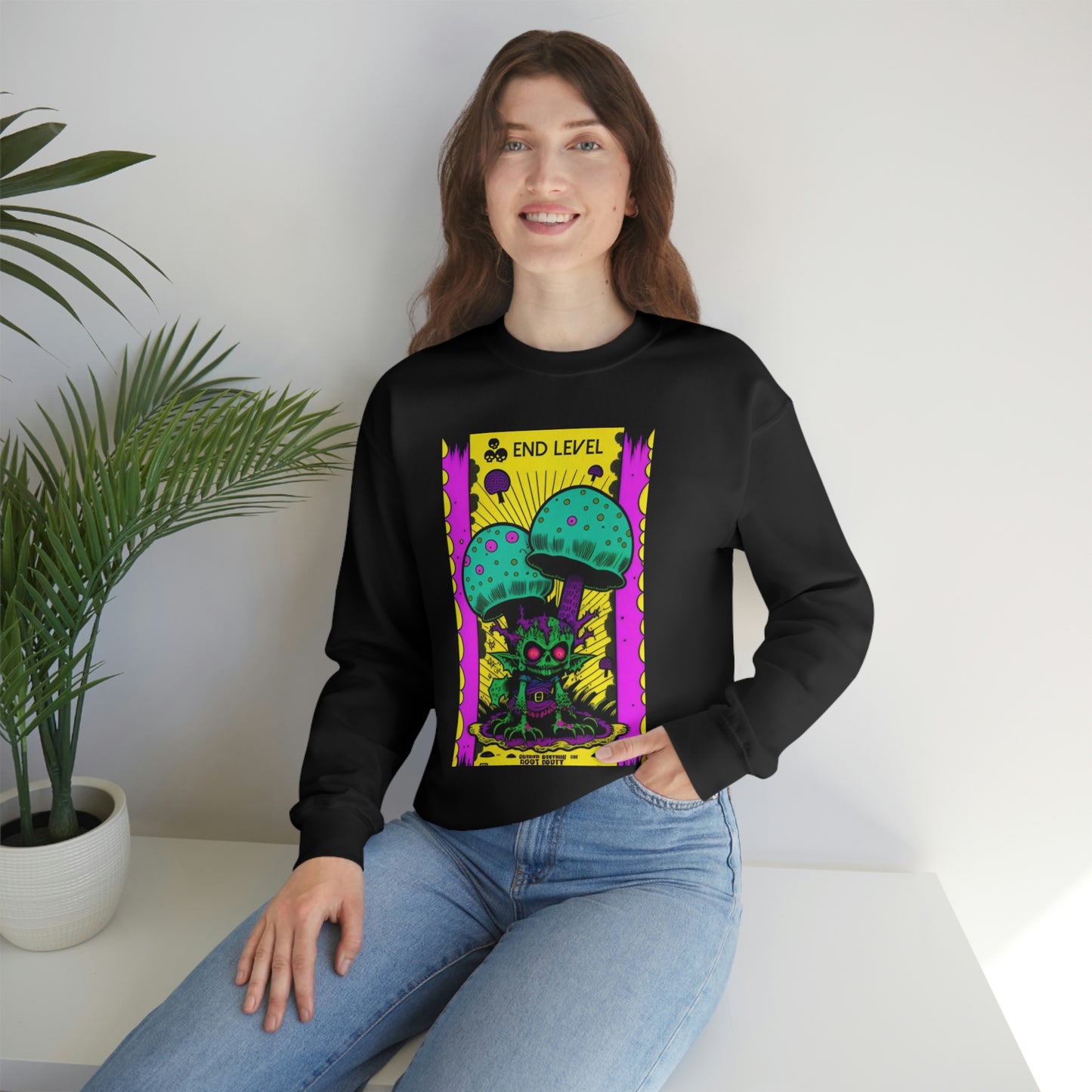 Woman with hand in jean pocket wearing black Tea Time sweatshirt beside plant.