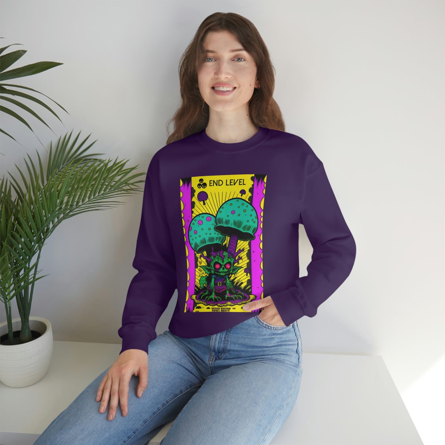 Woman with hand in jean pocket wearing purple Tea Time sweatshirt beside plant.