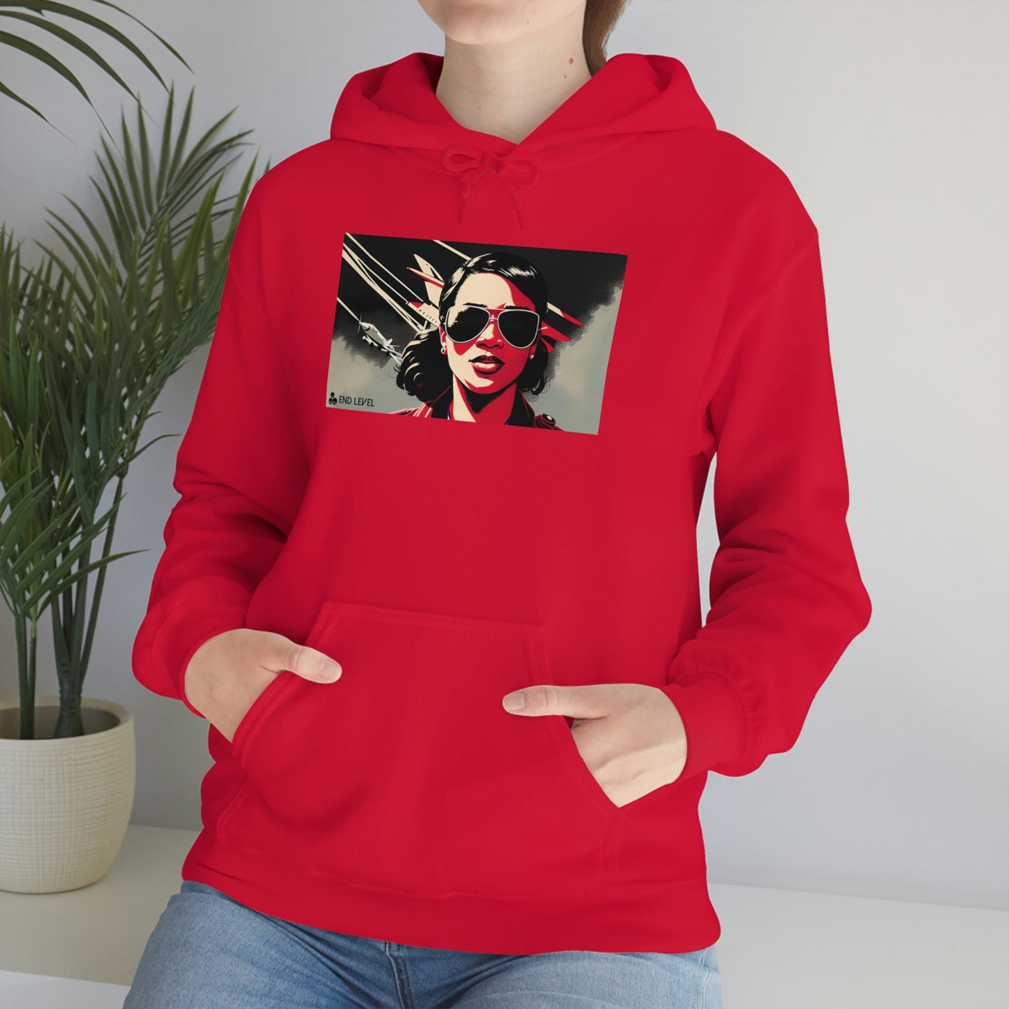 Woman sitting beside plant wearing red Ace hoodie.