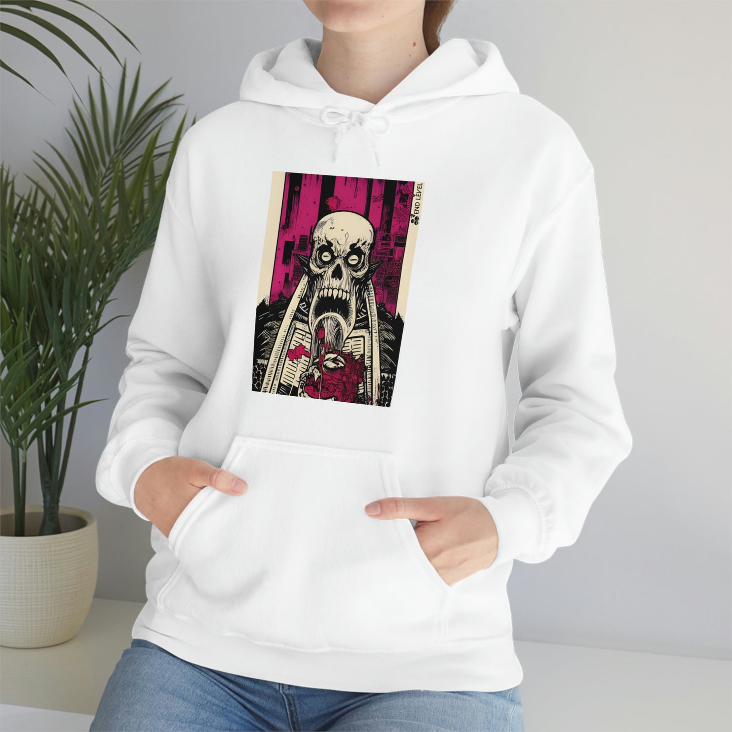Woman sitting beside plant wearing Sangre white hoodie.