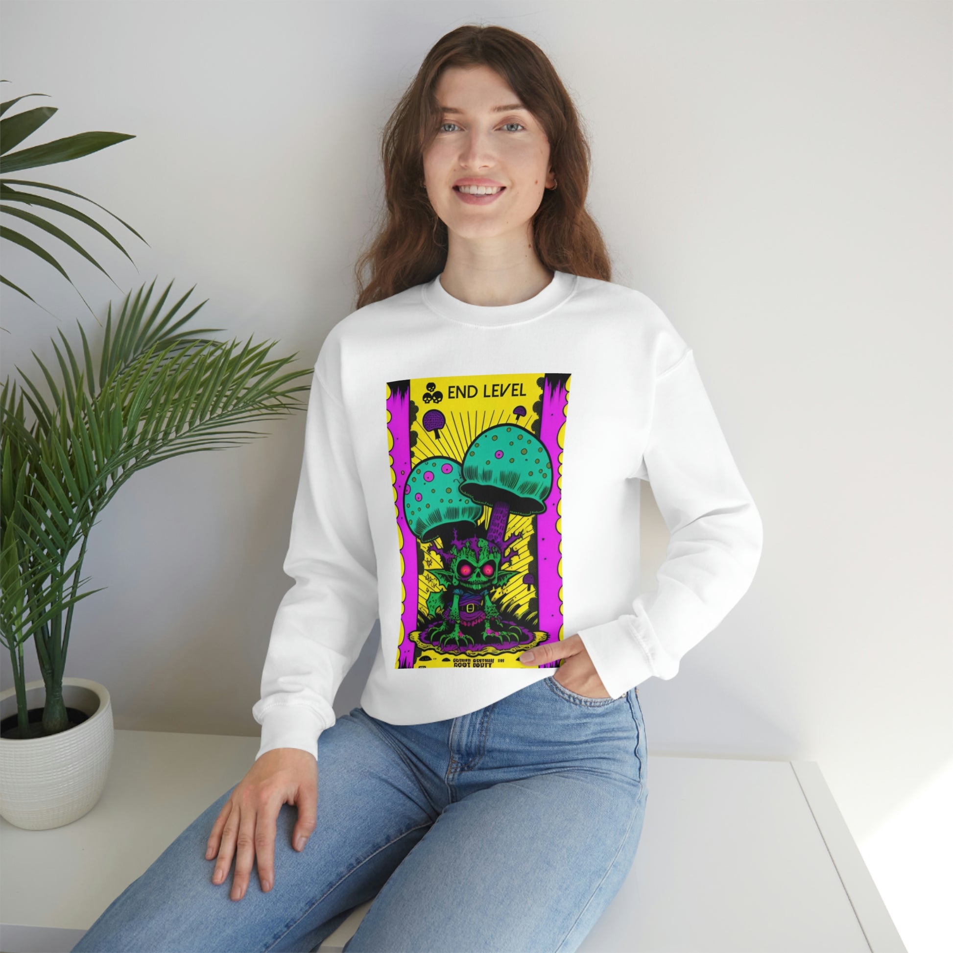 Woman with hand in jean pocket wearing white Tea Time sweatshirt beside plant.