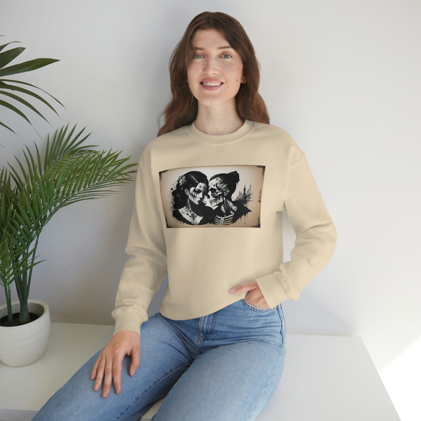 Woman with hand in jean pocket wearing Love Eternal white sweatshirt beside plant.